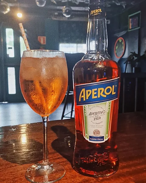 Aperol Spritz naast een fles Aperol op de bar
