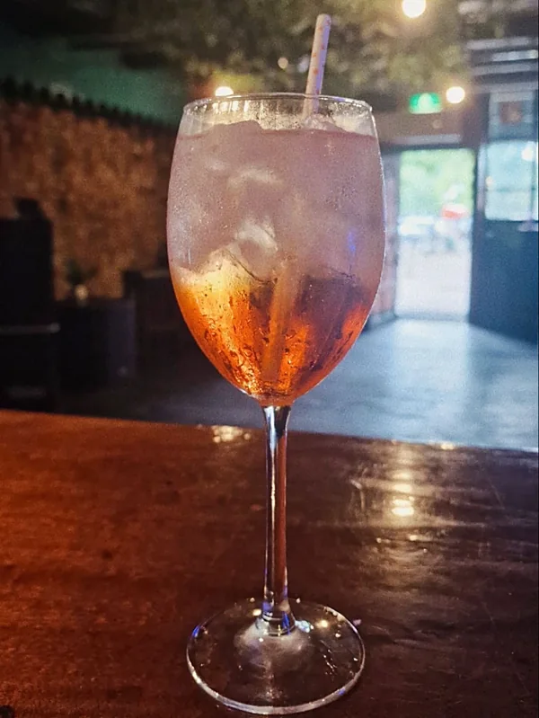 Een spritz op de bar, met de open deur naar de straat